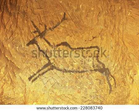  Black carbon paint of deer on sandstone wall, copy of prehistoric picture. Abstract children art in sandstone cave.