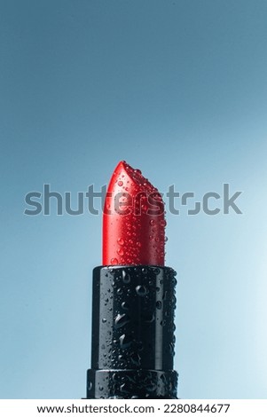 Moisturizing red lipstick close-up with water drops