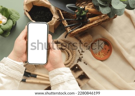 Phone with an isolated screen for your text on the background of garden tools.