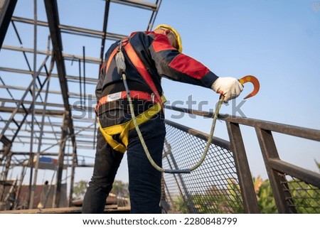Construction worker use safety harness and safety line working on a new construction site project. Royalty-Free Stock Photo #2280848799