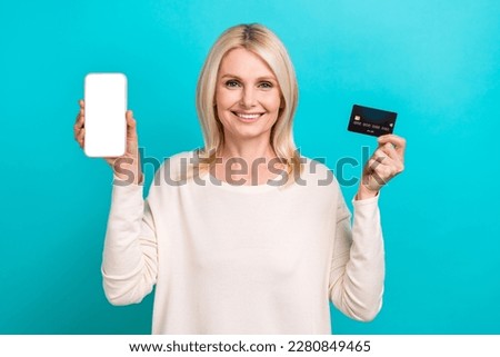 Photo of charming cute lady dressed white shirt rising bank card modern device empty space isolated teal color background