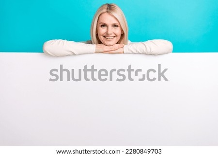 Photo of cute adorable woman wear white shirt holding poster empty space isolated turquoise color background
