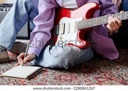 Musician with guitar writing new song Royalty-Free Stock Photo #2280861267