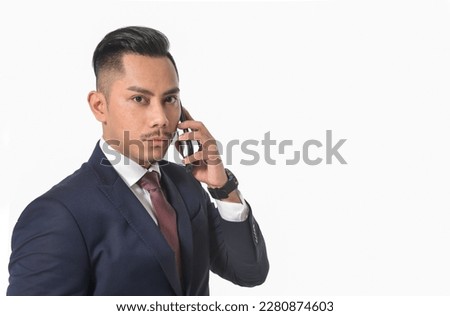 Portrait of young business man in black suit,tie using cellphone 