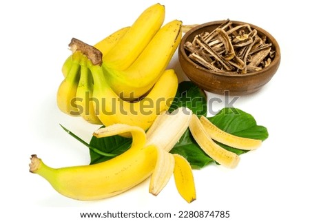Dried bananas in the bowl and fresh bananas isolated on white background. Sticks of dehydrated banana pulp. Healthy, no sugar food, fruit snack. 