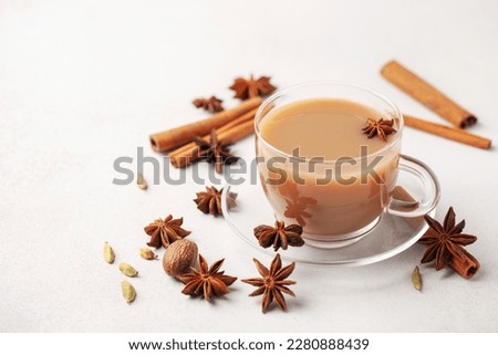 Masala tea or karak chai in a glass cup with cardamom, star anise and cinnamon.  Royalty-Free Stock Photo #2280888439