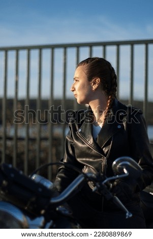 Biker woman with braids happy with her motorcycle