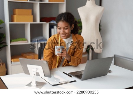 American African Fashion designer working in studio with laptop computer