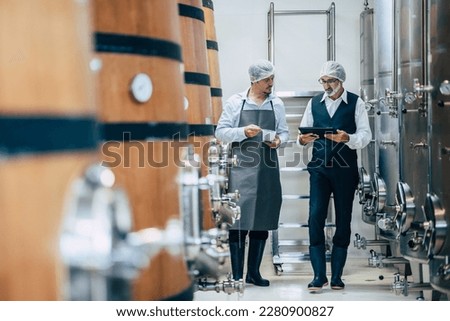 Winemaker working in modern large winery factory liquor drink industry quality and fermentation monitor  Royalty-Free Stock Photo #2280900827