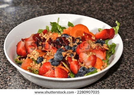 Salad with fruits in a white bowl