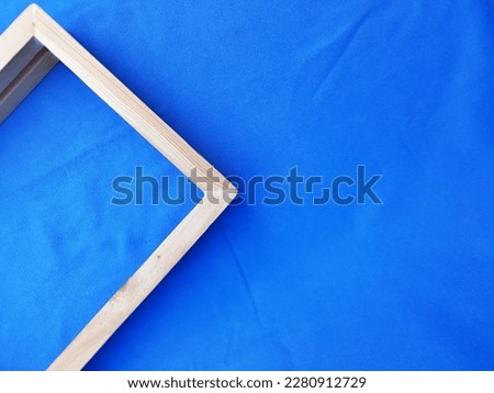 Empty wooden picture frame square box isolated in colorful gradient blue background. Selective focus