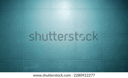 close up light blue square tile pattern with light from above used as background. abstract large rustic bathroom tile pattern. slate tile ceramic for modern interior decoration style.