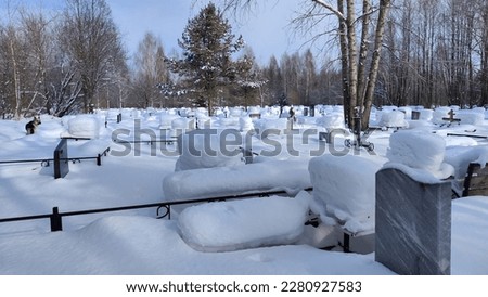 Ukrainian traditional cemetery in winter snow. Many of unmarked and faceless gravestones and crosses with forest in background. Graves in Russia after war