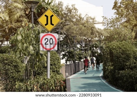 Speed limit road signs and Winding Road Sign with biker on twisty road background.Traffic signs warning drivers that conditions ahead may make it unsafe to drive 
