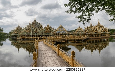 Panoramic photo of the architectural park of Oriental culture. Religious buildings of Thai history: palace and temple complexes. The exhibits are surrounded by ponds, tropical greenery and flowers