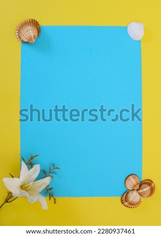 White flower and shells on a blue background surrounded by yellow.