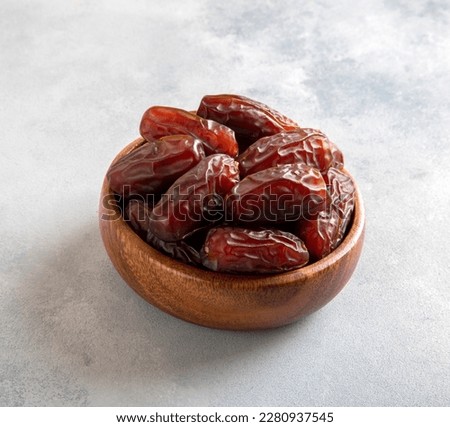 Date fruits in wooden bowl,on bright background,square shape