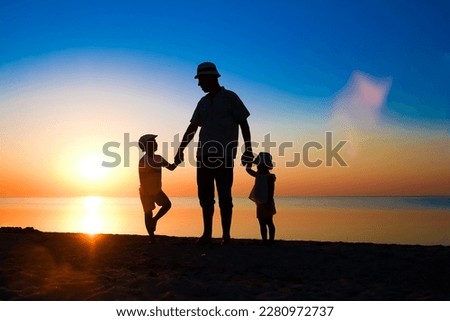 Happy parent with child by the sea play on nature silhouette travel