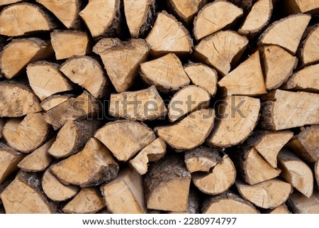 Pile of firewood stocked outdoors, in close up
