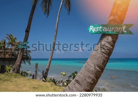 Restaurant sign arrow on palm tree on blue sea background