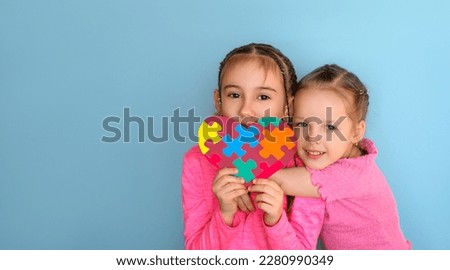 Children hold an autism symbol in their hands as a sign of support for special people with disabilities. A banner with an empty space for text.