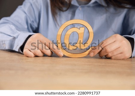 the woman holding wooden email sign on table background