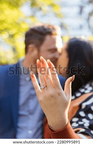 woman showing off engagement ring on her hand while kissing her fiance Royalty-Free Stock Photo #2280995891