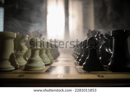 Chess board game concept of business ideas, competition and strategy. Chess figures on a dark background with smoke and fog. Selective focus