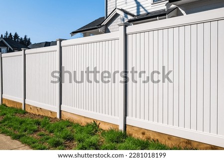 Nice new wooden fence around house. Wooden white fence with green lawn. Street photo, nobody, selective focus Royalty-Free Stock Photo #2281018199