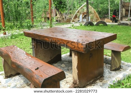 view of resting place of chair and table with wooden material in garden with nature background