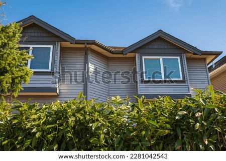 Top of a house with nice windows in the blue sky background. Beautiful Home Exterior. Real Estate Exterior Front House in a residential neighborhood. Nobody, street photo, copyspace for text