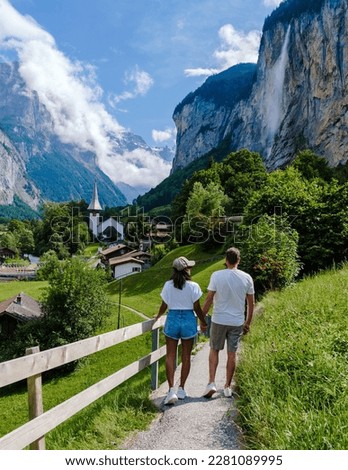 Couple visiting Lauterbrunnen valley with a gorgeous waterfall and Swiss Alps in the background, Berner Oberland, Switzerland, Europe. Royalty-Free Stock Photo #2281089995