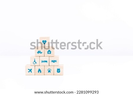 Hand holding wooden block stacking on white table and background. healthcare and insurance icon on wood cube arranged in a pyramid. copy space and isolated.