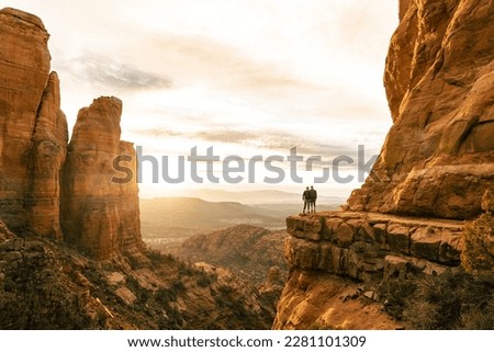 Young couple side by side are on top of Cathedral Rock in Sedona pose for horizontal photo. Royalty-Free Stock Photo #2281101309