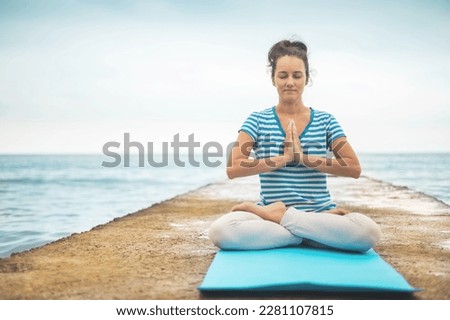 Yoga woman meditation in lotus position at pebble sea beach sunset sky horizon enjoy healthy lifestyle. Sports female gymnastic exercising spiritual mindfulness harmony balance evening seashore
