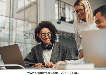 Group of positive business colleagues working together on project in modern coworking Royalty-Free Stock Photo #2281121183