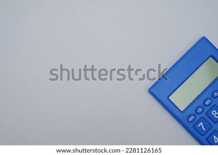 A calculator is a small electronic device used for mathematical calculations. It has a numerical keypad and a digital display. This particular calculator is pictured on a white background.