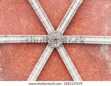 Bottom view of a red brick ceiling with a stone arch