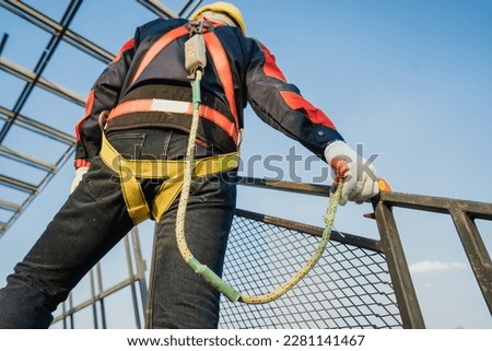 Construction workers wearing safety harnesses and harnesses work at heights in safety body structures. working at height Worker fall protection with hook for safety harness Royalty-Free Stock Photo #2281141467