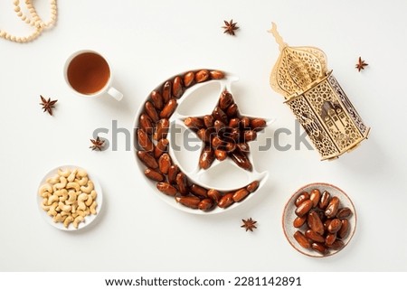 Muslim Ramadan iftar food, arabic lantern, rosary on white background. Dried dates fruit in crescent moon plate, Ramadan fasting.