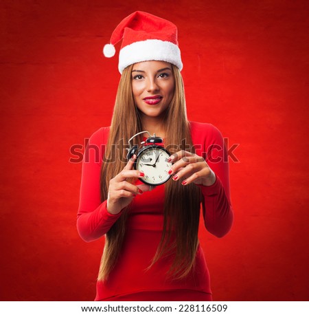 portrait of a beautiful young woman holding an alarm clock at Christmas