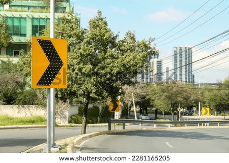 Yellow arrow road sign on city street