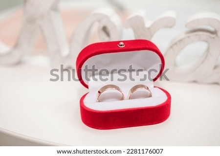 Two gold wedding rings in a red box