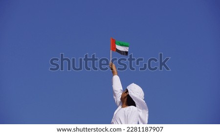 Emirati kid's hand holding flag of UAE. National day celebration by people of United Arab Emirates Royalty-Free Stock Photo #2281187907