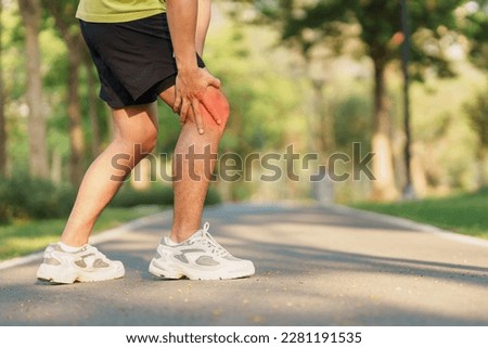 Young adult male with muscle pain during running. runner have knee ache due to Runners Knee or Patellofemoral Pain Syndrome, osteoarthritis and Patellar Tendinitis. Sports injuries and medical concept Royalty-Free Stock Photo #2281191535