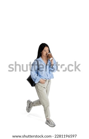 Top isometric view. Young girl in casual clothes in motion, walking and drinking coffee isolated over white studio background. Concept of business, employment, education. lifestyle. Copy space for ad Royalty-Free Stock Photo #2281196597