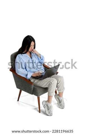 Top isometric view. Young girl in shirt sitting on chair and working, studying in laptop isolated over white studio background. Concept of business, employment, education. lifestyle. Copy space for ad Royalty-Free Stock Photo #2281196635