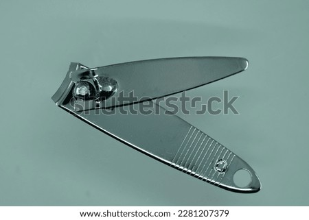 Close up of a nail clipper on a gray background with copy space