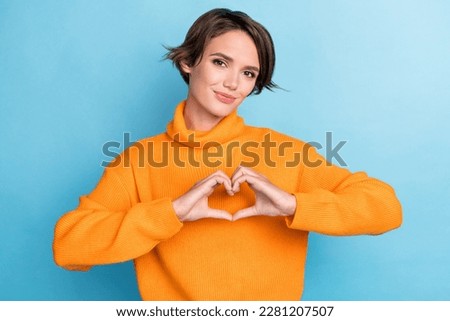Photo portrait of pretty young girl showing fingers heart love gesture feedback wear trendy orange look isolated on blue color background