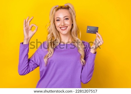 Photo of pretty confident woman wear violet shirt showing okey holding bank card isolated yellow color background